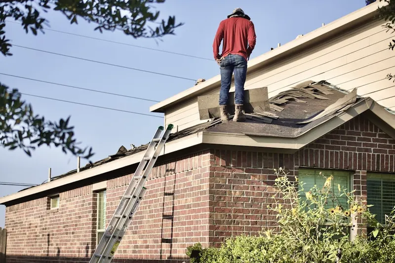 Professional roofer working on a residential roof in Midway Hollow